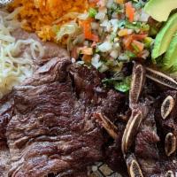 Arrachera Y Costillitas De Res · Beef Skirt Steak & Beef Short Ribs

Served with a side of rice, refried beans, a bed of lett...