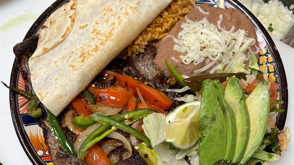 Bistec A La Chona · Carne Asada La Chona Style

Grilled bistec topped with grilled onions, tomatoes, jalapeño peppers and a plain quesadilla. Served with a side of rice, refried beans, a bed of lettuce topped with pico, avocado slices and a pickled jalapeño pepper & tortillas.