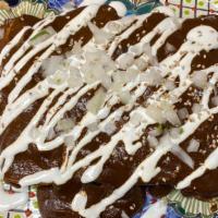 Enchiladas Poblanas (4) · 4 shredded chicken enchiladas topped with Poblano mole, sesame seeds, sour cream & dice onio...