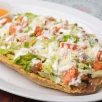 Huarache · Mexican thick corn tortilla shaped like a boat

Topped with refried beans, meat of choice, s...