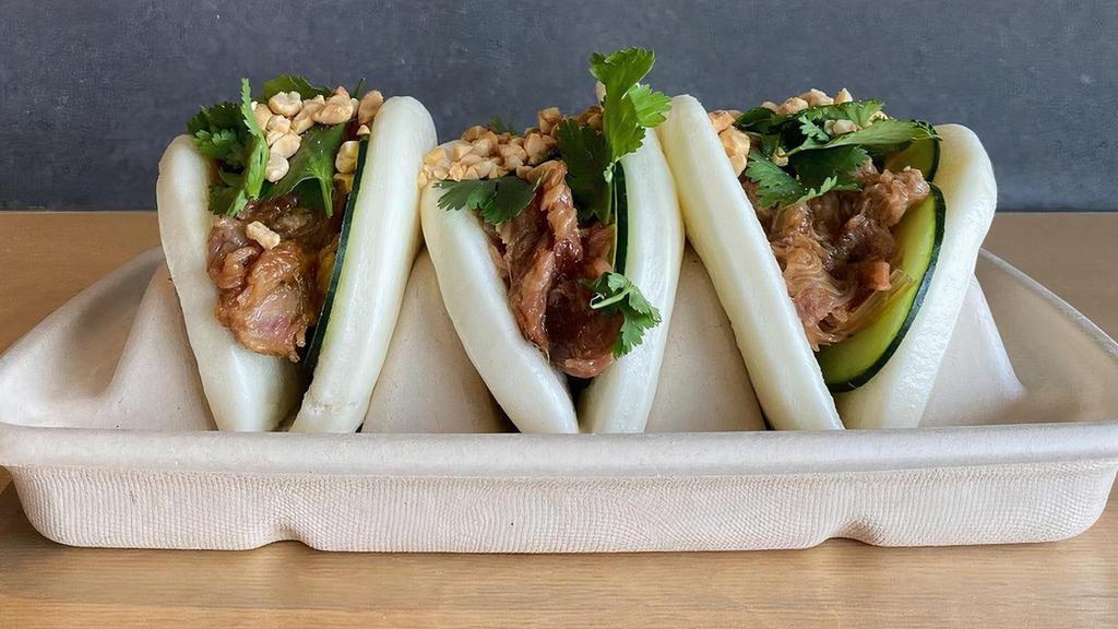 Bao Buns · a FUSIAN first! -- three freshly steamed buns, filled w/ house-marinated pork (or sub for chicken or tofu), cucumber slaw, and topped w/ chopped peanuts + cilantro