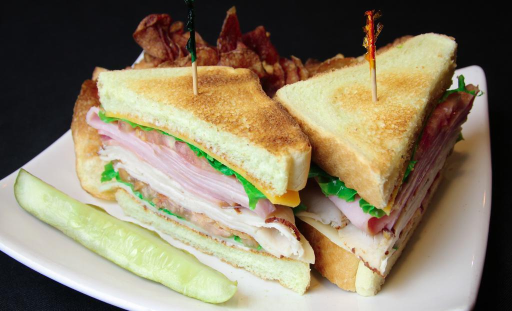 Club · Ham, smoked turkey, apple smoked bacon, sharp cheddar and aged swiss cheese served on toasted white bread with mayonnaise. Served with shredded iceberg lettuce, tomato, house kettle chips, and a pickle spear.