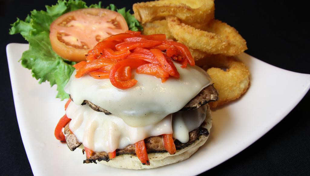 Portobello Sandwich · Portobello caps layered with roasted red peppers and provolone cheese served with our roasted garlic aioli on a rosemary focaccia bun. Served with shredded iceberg lettuce, tomato, house kettle chips, and a pickle spear.