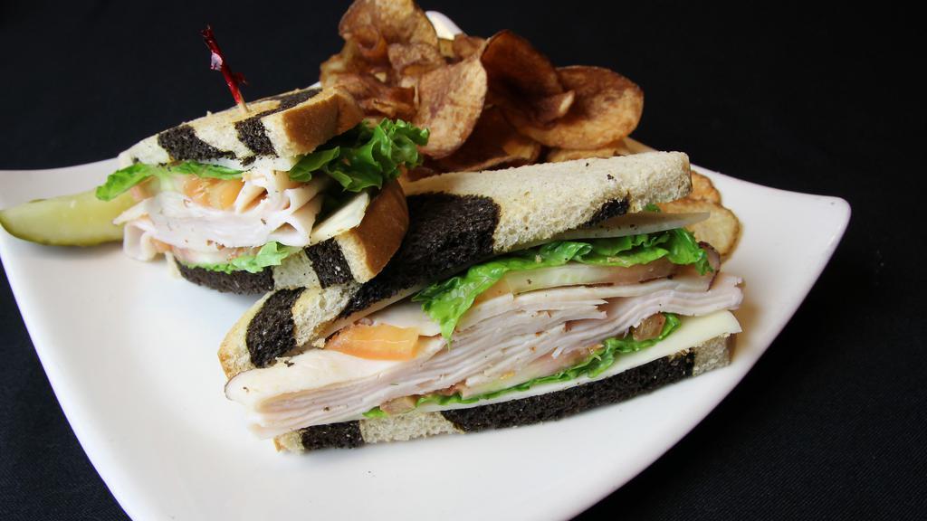 Turkey Sandwich · Smoked turkey and aged swiss, served on toasted marble rye. served with shredded iceberg lettuce, tomato, house kettle chips, and a pickle spear.