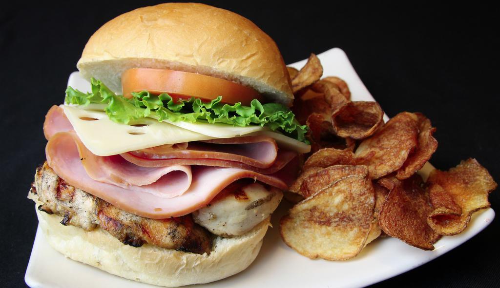 Cordon Bleu · Marinated grilled chicken breast, layered with cured ham and melted swiss cheese. Served on a kaiser bun. served with shredded iceberg lettuce, tomato, house kettle chips, and a pickle spear.