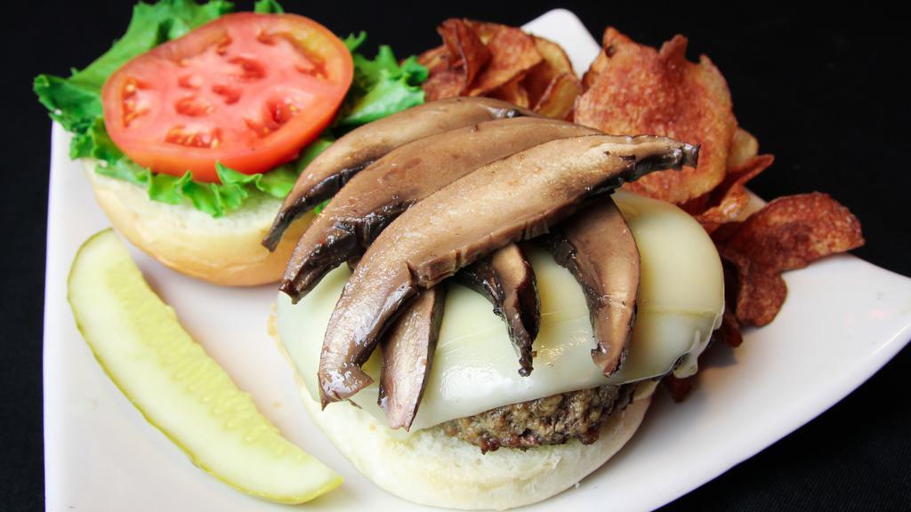 Brown Bomber Portobello · Half pound patty with sliced portobello mushrooms and swiss cheese. Served with shredded iceberg lettuce, tomato, house kettle chips, and a pickle spear on a raised kaiser bun.