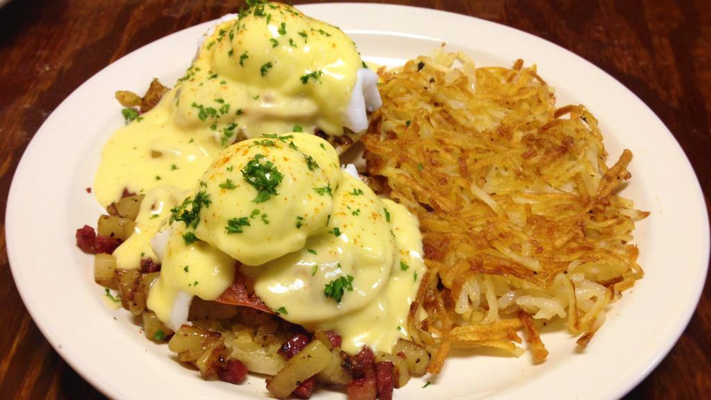 Irish Eggs Benedict · English muffin halves topped with corned beef hash, sautéed tomatoes, two poached eggs, and hollandaise sauce.
