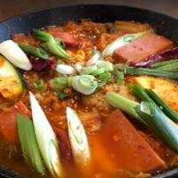 Budae Jigae / 부대찌게 · Stew loaded with kimchi, tofu, spam, sausages, ramen noodles, rice cakes, mushrooms, scallio...