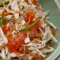 Spicy Cabbage Salad (V) · Shredded cabbage, carrots, tomatoes, roasted Thai chilies & ground peanuts tossed in vinaigr...