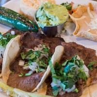 Lomo Taco Dinner · 3 thin cut rib eye tacos topped with cilantro & onion & served with a side of guacamole, gri...