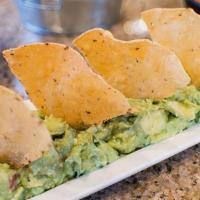 Small Guac N Chips · Bowl of avocado dip with diced tomato, onion, and cilantro.