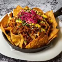 Cochinachos · Crispy tortilla chips topped with Cochinita Pibil (pulled pork), pickled red onions, and 
li...