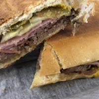 Tampa Cubano · Pressed Cuban bread with roasted pork, honey ham, geoniva salami, swiss cheese, pickles, and...