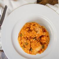 Arroz Con Pollo · Chicken breast seasoned and cooked in chunks with yellow rice marinated in onions, peppers, ...