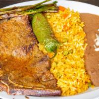 Carne Asada · Grilled diezmiello or Chuleta del 7 served with red rice, beans, salad,  roasted peppers and...