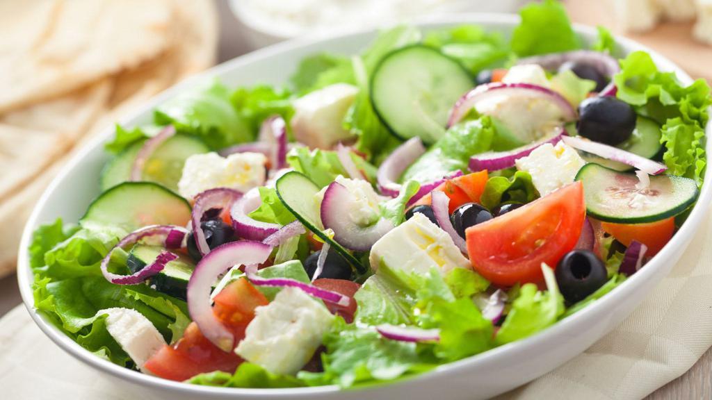 The Greek Salad · Crisp romaine lettuce, fresh cucumbers, ripe tomatoes, black olives and tangy feta cheese with our house Greek vinaigrette, served on the side.
