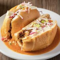 Torta Ahogada · Braised pork carnitas, queso panela, pickle red onions and cabbage salad on telera bread, ro...