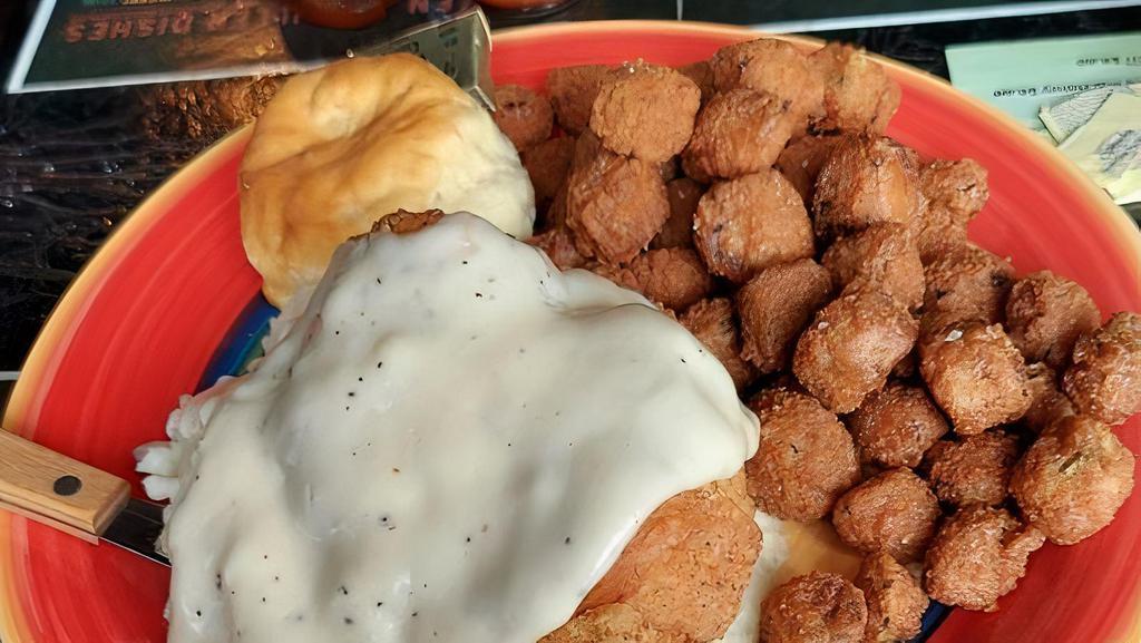 Chicken Fried Chicken · Fried breast topped with white country gravy, with a side of mashed potatoes, your choice of one fixin' and a biscuit.