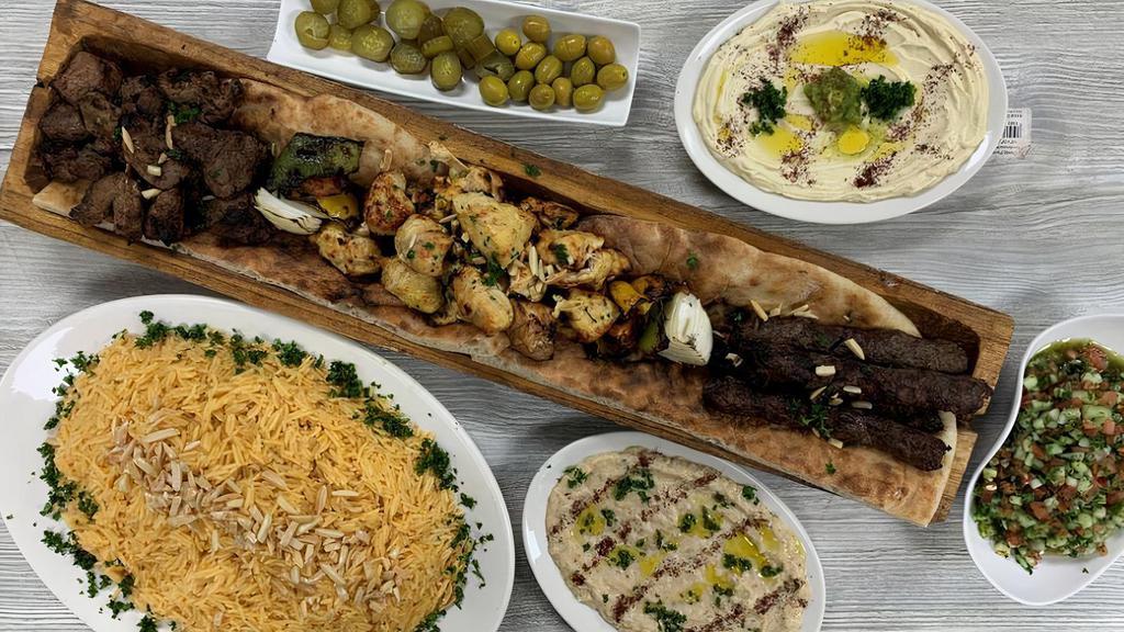 Large Mixed Grill · Four skewers of shish kabob, four skewers of chicken shish tawook, four skewers of kufta kabob, one side of hummus,  one side of baba ghanoug, one side of salad, large plate of rice, one taboun bread.