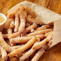 Churro Fries · Bite sized churros coated with cinnamon and sugar, served with dulce de leche caramel dippin...
