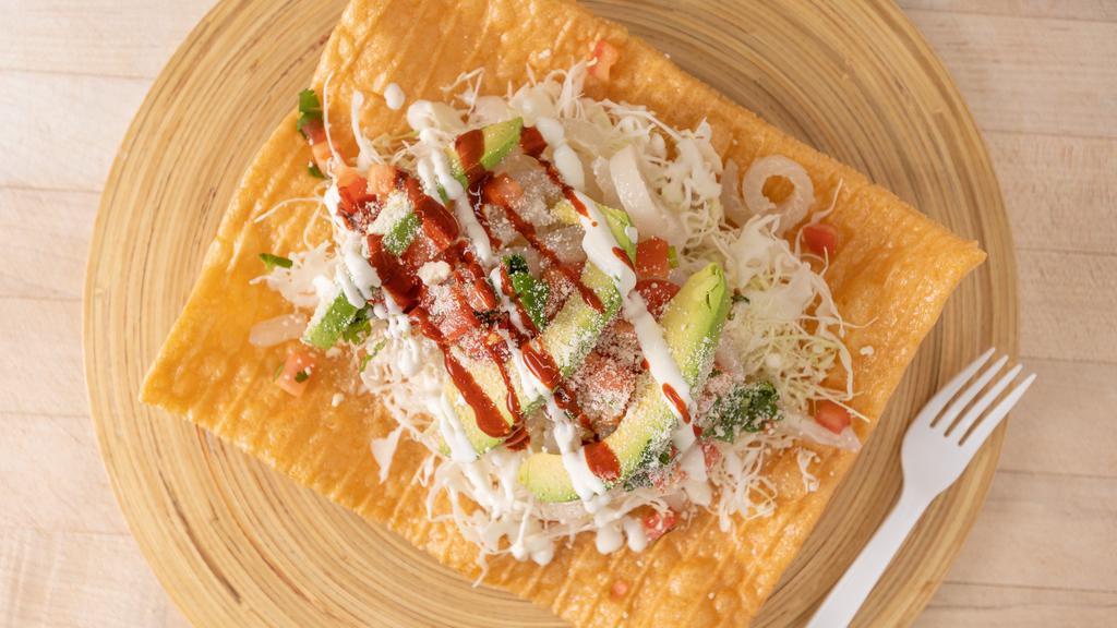 Chilindrina · Wheat tostada topped with pork rinds, cheese, avocado and sour cream -.
