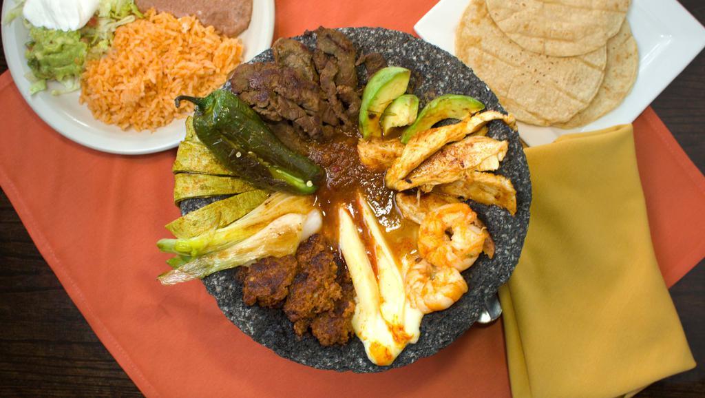 Molcajete · Sizzling hot lava rock filled with steak, chicken, chorizo, shrimp, onions, cactus, panela cheese, and ranchera salsa. Served with rice, beans and tortillas