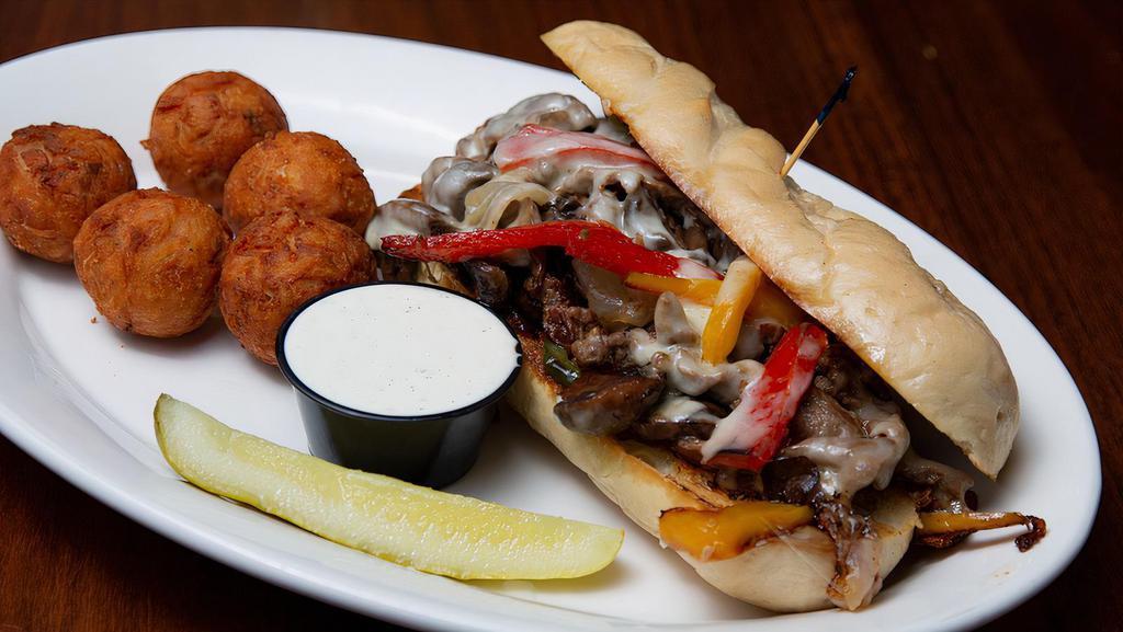 Loaded Philly Cheesesteak · Our Traditional Philly Cheesesteak adding caramelized onions, wild mushrooms, melted provolone and mixed bell peppers. Served with fries. (shown with tots upgrade)