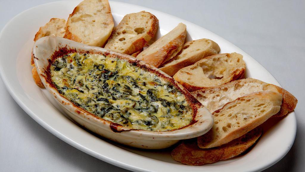 Artichoke Dip · Spinach, artichoke hearts, garlic and three cheese blend with cream cheese in a white sauce. Served with baguette slices.