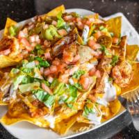 Chicken Shawarma Nachos · Traditional home fried and seasoned corn chips topped with mixed cheese and nacho cheese, le...