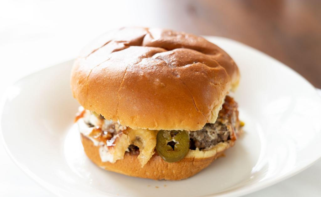 Jalapeno Popper Burger · A favorite snack done right! A generous portion of cream
cheese spread, sautéed
jalapeños, crispy French fried
onions and our tangy BBQ
sauce to top it off! Tip: it’s even
better with bacon!.