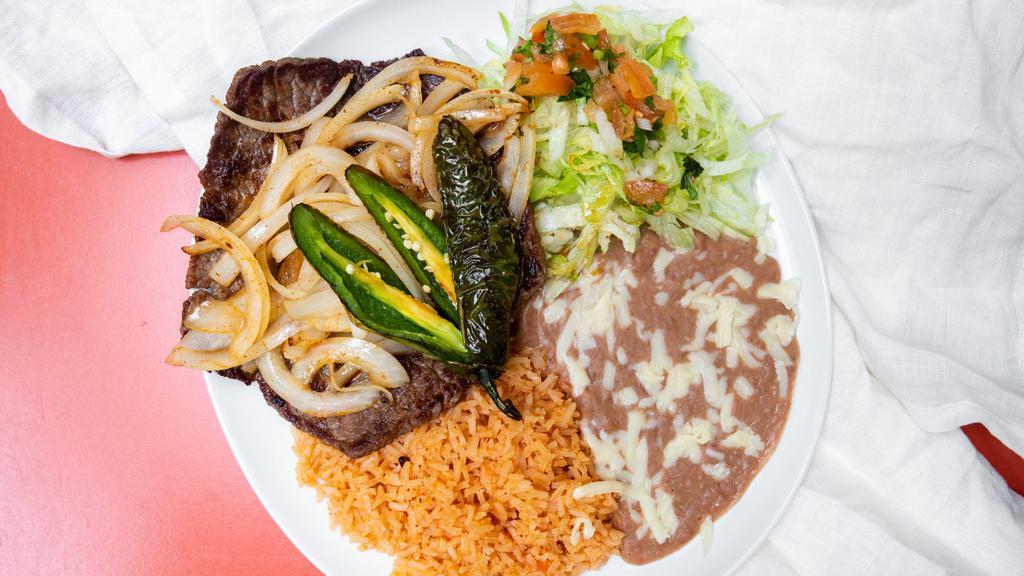 Carne Asada · Authentic carne asada (steak) and fried onions. Served with rice, refried beans, salad, tortillas (corn or flour), and a fried jalapeño. Beverage is included.