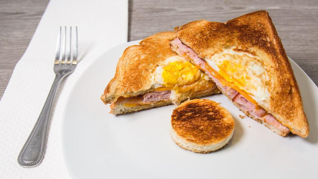 Eggs In A Basket Sandwich · Choice of turkey, bacon, sausage or ham with a fried egg and Cheddar cheese on grilled potato bread.