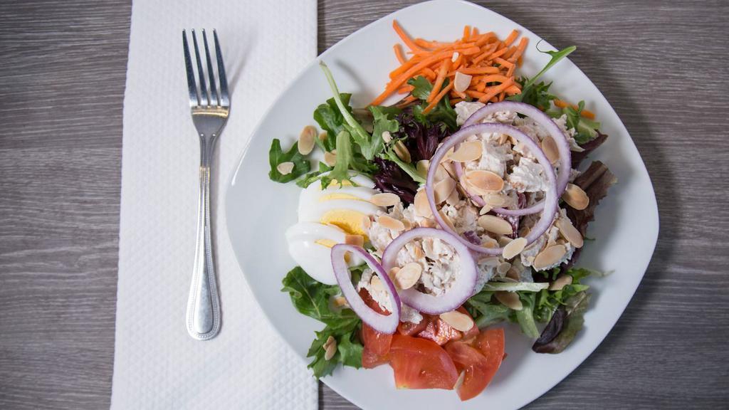 Roasted Chicken Salad · Contains nuts. House-made chicken salad with cubes of roasted chicken, red peppers, red grapes, and almonds tossed in a delicious mixture of mayo and spice served over lettuce with sliced hard boiled eggs and tomatoes.