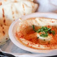 Hummus · Smooth dip of garbanzo beans, tahini sauce and garlic, topped with olive oil, served with tw...
