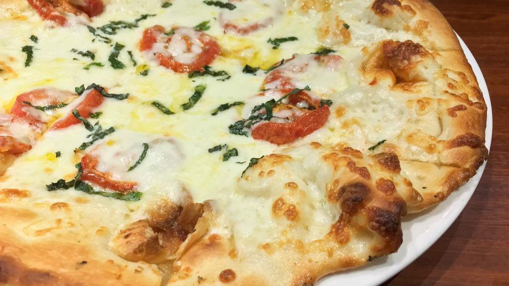Pizza Primavera · Vine ripened tomatoes, thick cut fresh mozzarella, and torn basil finished with olive oil.