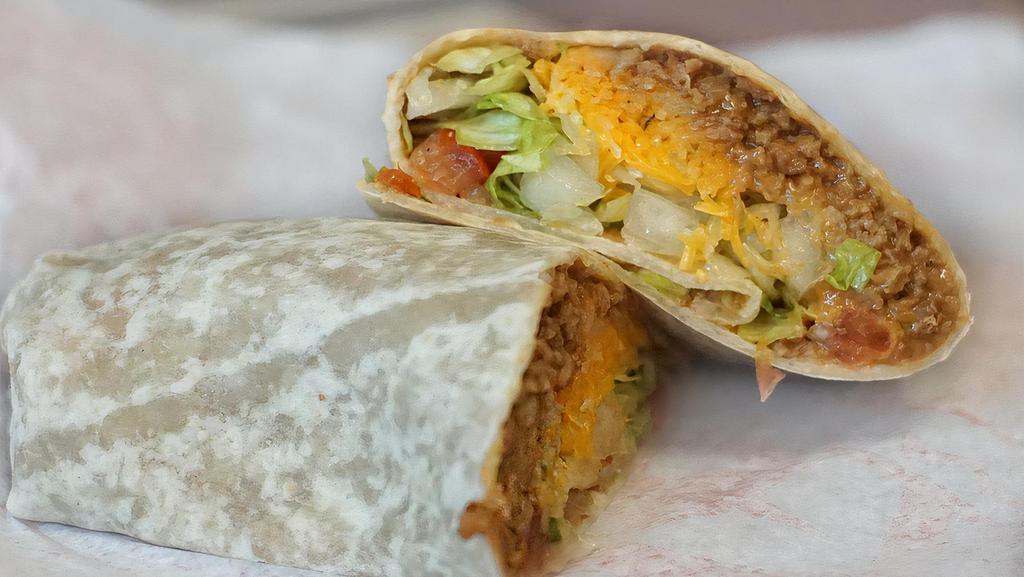 Taco Burrito · Wrapped in a flour tortilla, a mixture of seasoned ground beef and refried beans, lettuce, cheese, onion, and tomato.