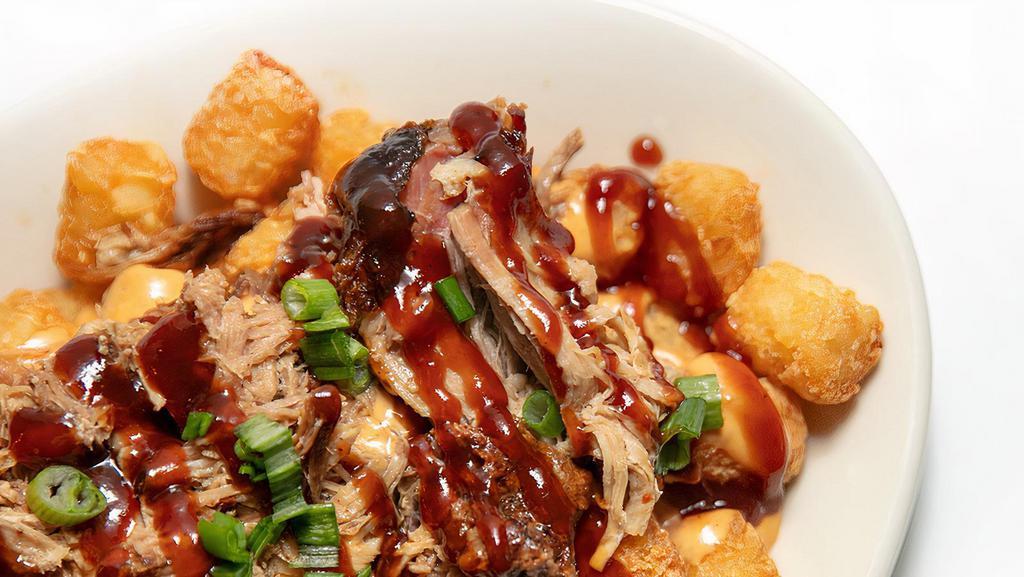 Totchos · Crispy tater tots topped with homemade queso, pulled pork, scallions, and bbq sauce.