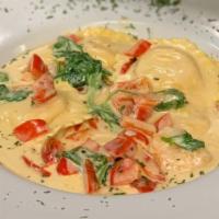 Lobster Ravioli & Shrimp · Saffron pillows of pasta filled with lobster meat, mozzarella cheese and brandy. Tossed in g...