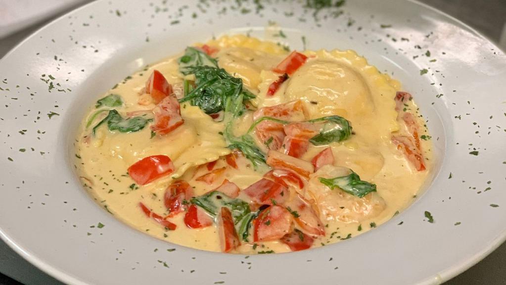 Lobster Ravioli & Shrimp · Saffron pillows of pasta filled with lobster meat, mozzarella cheese and brandy. Tossed in garlic cream sauce with shrimp, red peppers and spinach.