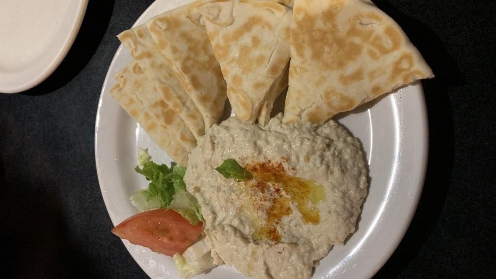 Baba Ganoush · Roasted eggplant mixed with garlic, lemon juice, tahini sauce, drizzled with olive oil, and served with pita.