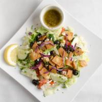 Fattoush Salad · Iceberg lettuce, tomato, cucumber, feta cheese, Kalamata olives and pieces of crispy pita cr...
