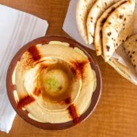 Hummus · A smooth dip of garbanzo beans, tahini sauce and garlic, topped with olive oil, served with ...