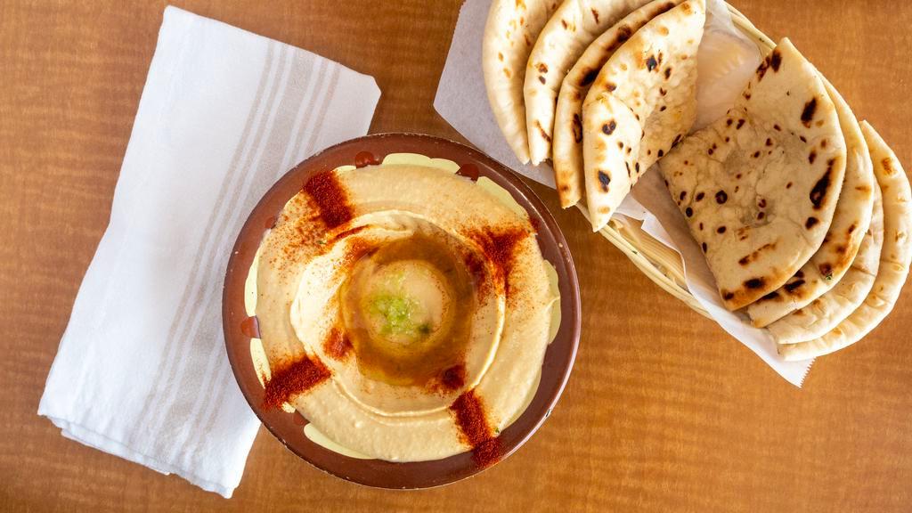 Hummus · A smooth dip of garbanzo beans, tahini sauce and garlic, topped with olive oil, served with two hot pita bread.