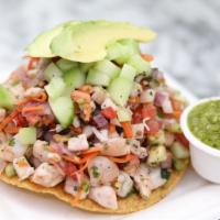 Mix Tostada · Fish and Shrimp Ceviche on a corn tostada with slices of avocado.