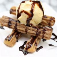 Churros Locos · Mexican cinnamon churros covered with chocolate syrup and vanilla ice cream.