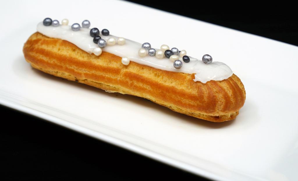 Eclair Vanilla · A great classic of the French patisserie, our eclairs are made from choux pastry, filled with vanilla flavored custard, and dipped in vanilla fondant icing.
