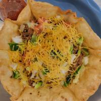 Taco Salad · Crisp tortilla shell filled with lettuce topped with seasoned ground beef, shredded cheddar ...