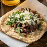 Lime-Grilled Steak Taco - Single · Lime-marinated steak topped cheese, onion and cilantro on corn tortillas.