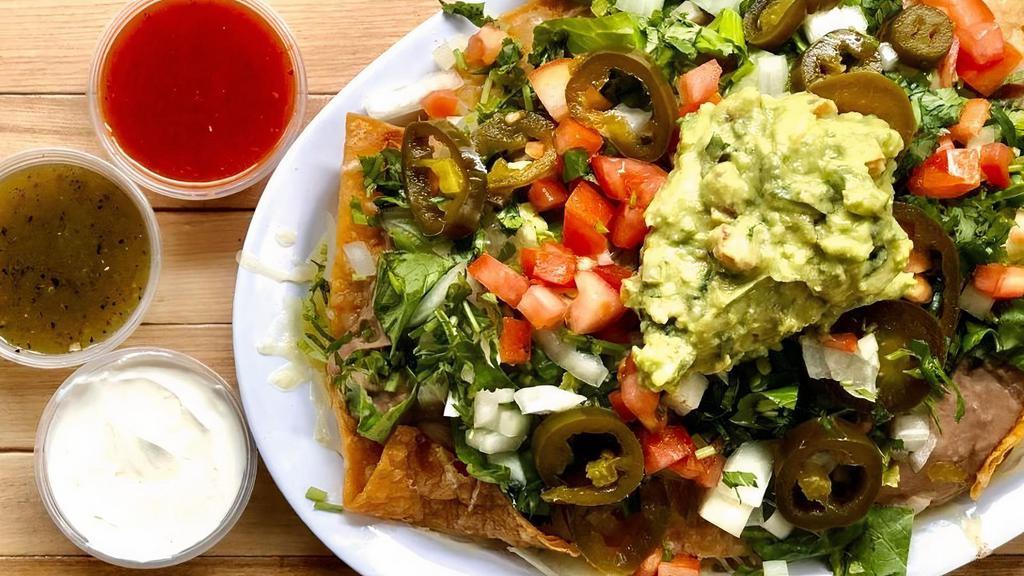 Nachos, Nachos, Nachos · Housemade tortilla chips smothered in Chihuahua cheese, guacamole, refried beans, diced tomato and onion, fresh cilantro, pickled jalapeños, lettuce, and sour cream.