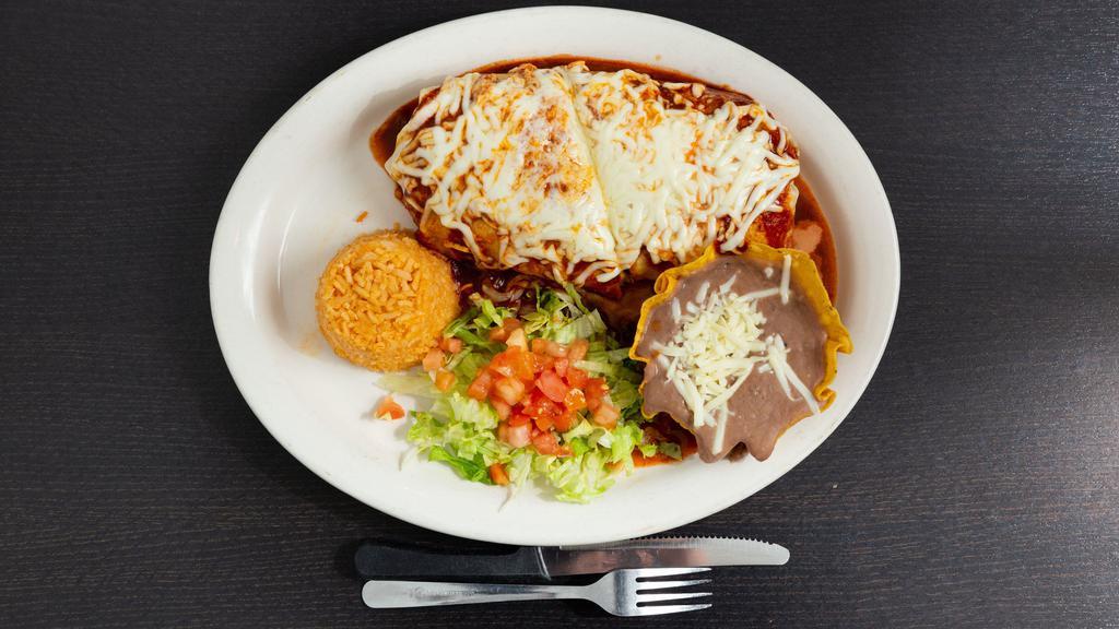 Burrito Suizo · Stuffed with your choice of meat (steak, al pastor, chorizo, chicken, ground beef or veggies) refried beans, lettuce, tomatoes, cheese, and sour cream. Topped with melted cheese and bufa sauce. Served with rice and beans.